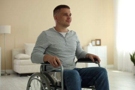 Young man in modern wheelchair at home