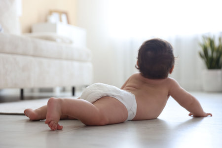 Cute little baby crawling on floor at home, selective focus
