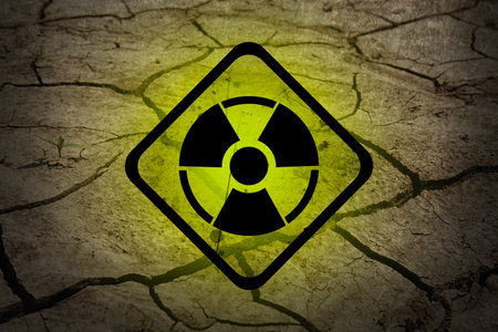 Yellow radioactive sign on cracked dry earth, closeup. Radiological pollutionの写真素材