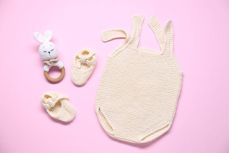 Baby clothes and accessory on pink background, flat lay