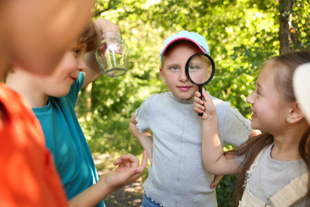 Group of children with magnifying glass in nature, selective focusの写真素材