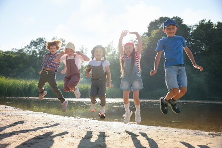 Happy children jumping in nature on sunny dayの写真素材
