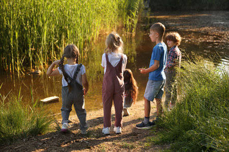 Children spending time by lake in natureの写真素材