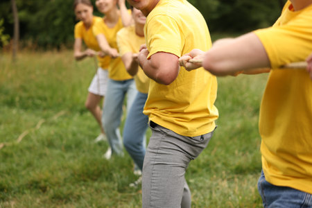 Team building. Group of people playing tug of war with rope outdoors, closeupの写真素材