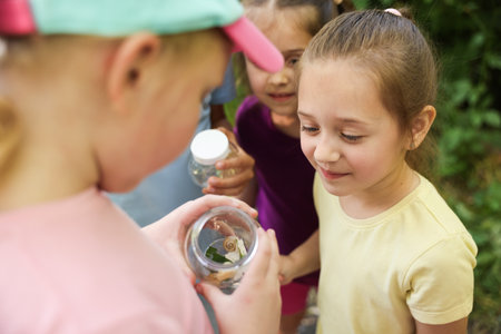 Children with jar of snails in nature, closeupの写真素材