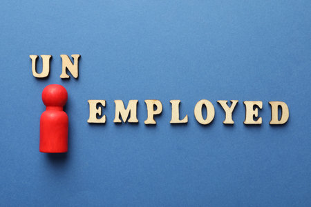 Word Unemployed and human figure on blue background, flat lay