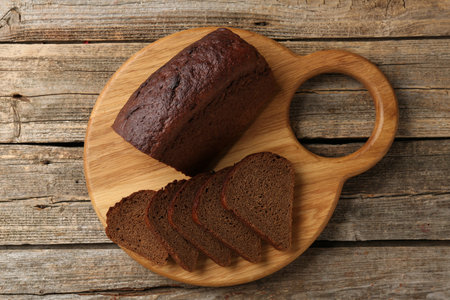 Pieces of fresh rye bread on wooden table, top view