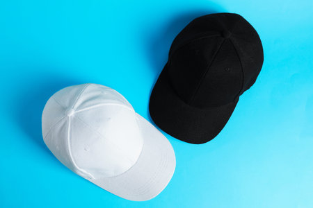 Baseball hats on light blue background, top view