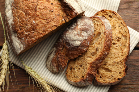Pieces of fresh bread on wooden table, flat lay