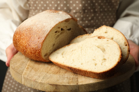 Woman with pieces of fresh bread, closeup
