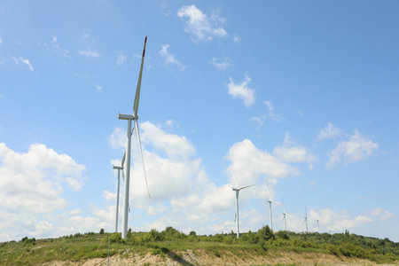Modern wind turbines in field on sunny day