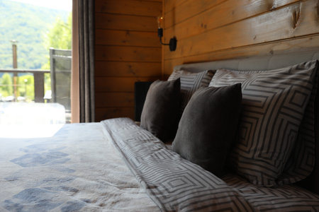 Comfortable bed near window in hotel room
