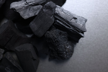 Pieces of black coals on table, above view