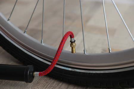 Bicycle and manual air pump indoors, closeup