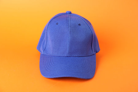 One blue cap baseball on orange background, closeup. Mockup for design