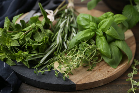 Different fresh green herbs on wooden table, closeup