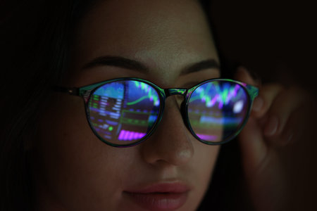Young woman wearing glasses with reflection on dark background, closeup
