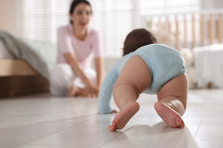 Mother with her cute little baby on floor indoors, selective focusの写真素材