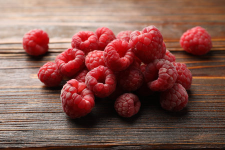 Tasty fresh ripe raspberries on wooden table, closeup