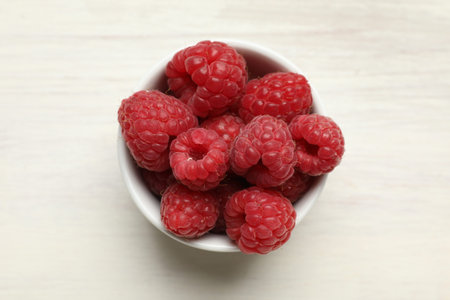 Tasty fresh ripe raspberries on white wooden table, top view