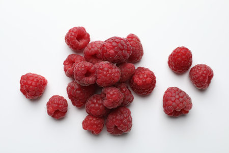 Tasty fresh ripe raspberries on white background, flat lay