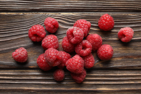 Tasty fresh ripe raspberries on wooden table, flat lay