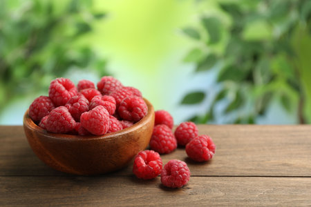 Tasty fresh ripe raspberries on wooden table, closeup. Space for text