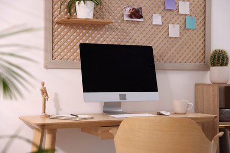 Stylish workplace with wooden desk, computer and stationery at home office. Interior design