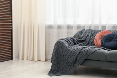 Stylish furniture near window with curtains in living room. Interior design