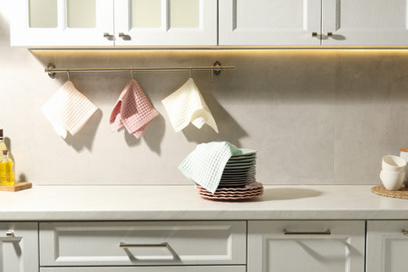 Clean waffle towels hanging on hook rack above counter in kitchenの写真素材