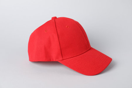 One red baseball cap on grey background, closeup. Mockup for design