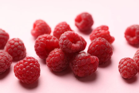 Tasty fresh ripe raspberries on pink background, closeup