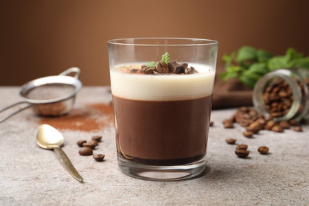 Delicious coffee panna cotta, beans and mint on grey table, closeup
