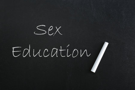Sex Education inscription and piece of chalk on black chalkboardの写真素材