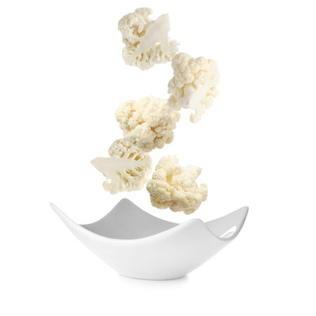 Cauliflower florets falling into bowl against white backgroundの写真素材
