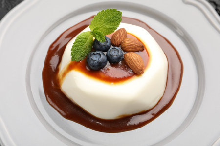 Tasty panna cotta with blueberries, almonds and sauce on plate, closeupの写真素材
