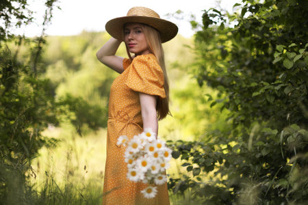 Beautiful woman with bouquet of wildflowers in forestの写真素材