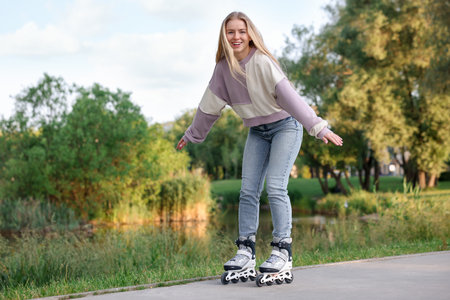 Happy young woman roller skating in park