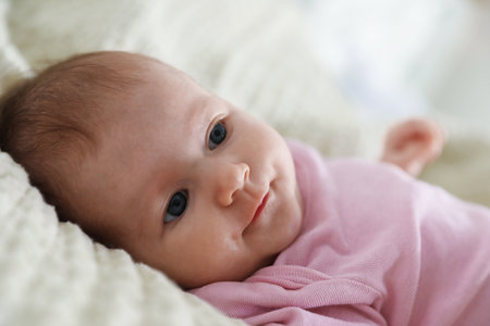 Cute newborn baby lying on bed indoorsの写真素材