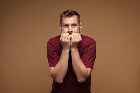 Man suffering from panic attack on brown background