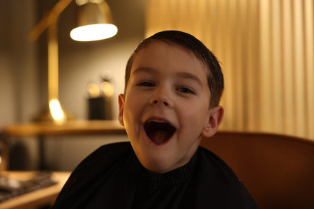 Portrait of cute little boy in barbershop
