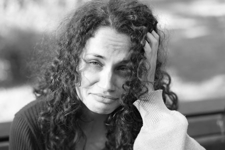 Portrait of homeless woman outdoors. Black and white effect