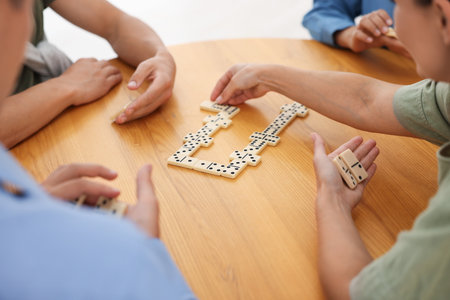 Friends playing dominoes at wooden table, closeupの写真素材