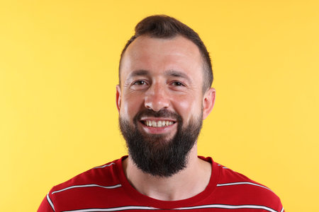 Man laughing on yellow background. Positive emotion