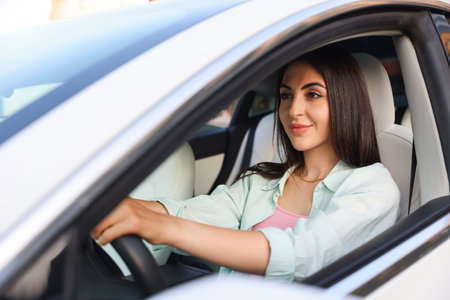 Woman holding steering wheel while driving car, view from outside