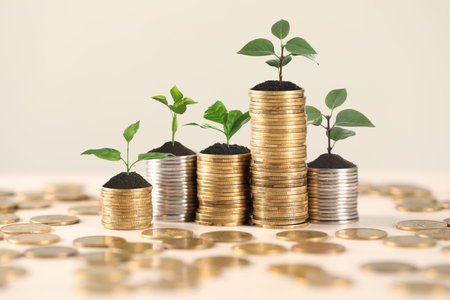 Savings concept. Stacked coins with sprouts on table