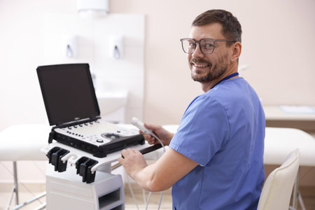 Professional sonographer with ultrasound machine in clinicの写真素材