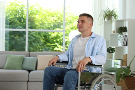 Young man in modern wheelchair at home