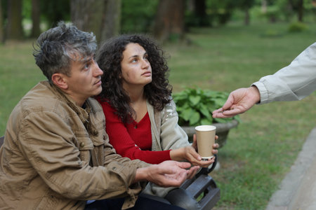 Man giving money to homeless people in park, closeupの写真素材