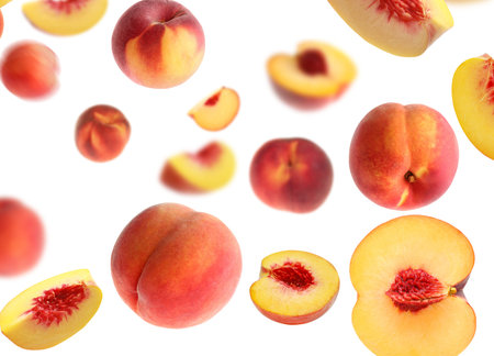 Fresh peaches whirling in air against white background